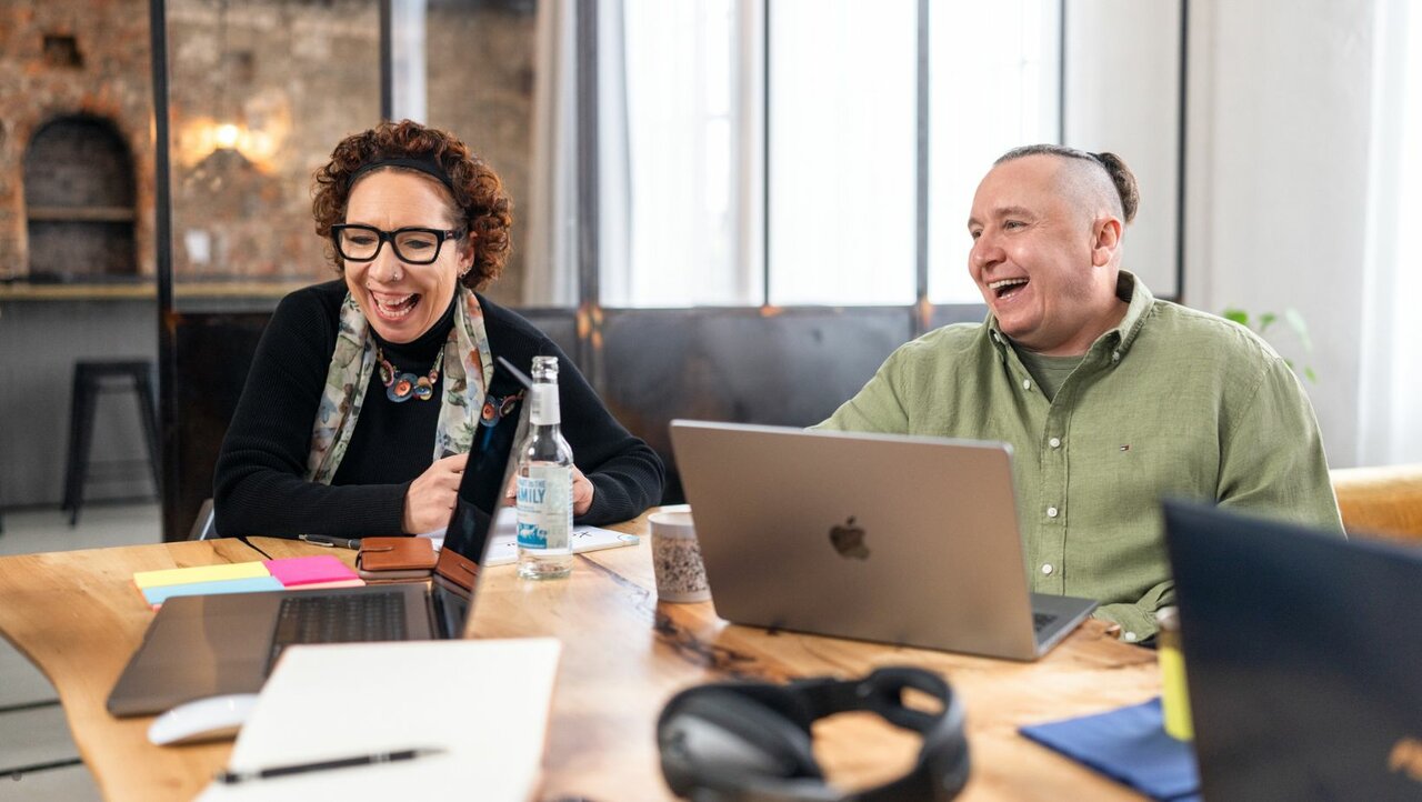 2 Kollegen arbeiten zusammen und lachen