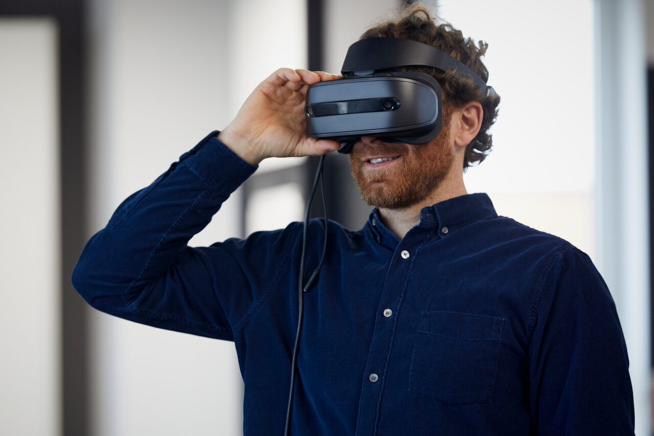 Ein Mann mit einer aufgesetzten VR Brille - Sinnbild für Visionen